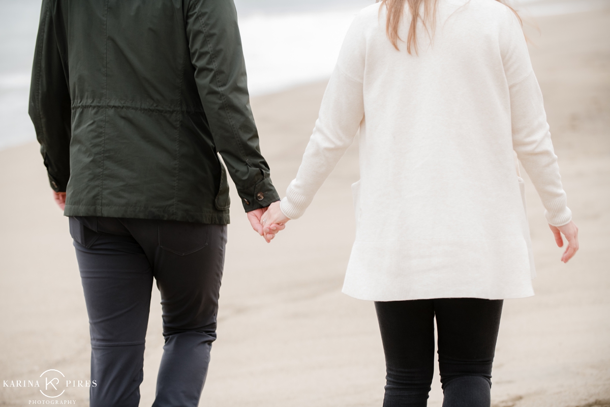 Couple holding hands for their photo session on Malibu beach