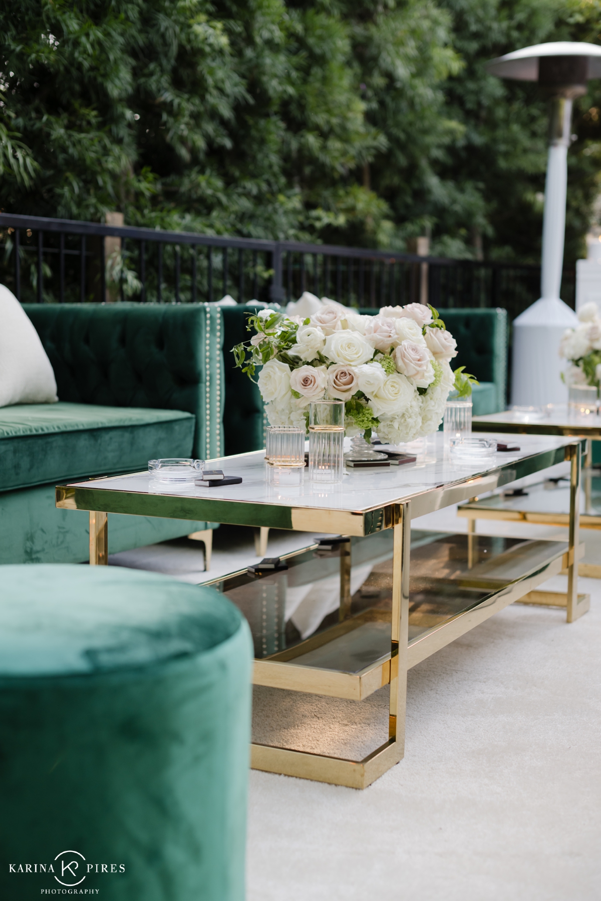 Green velvet lounge furniture with gold accents at a luxury wedding
