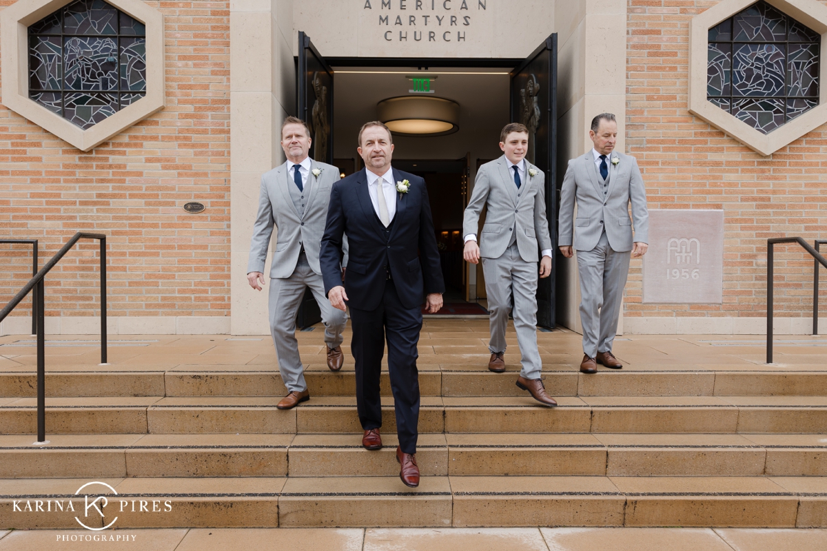 Groomsmen walking down the front steps at American Martyrs Catholic Church