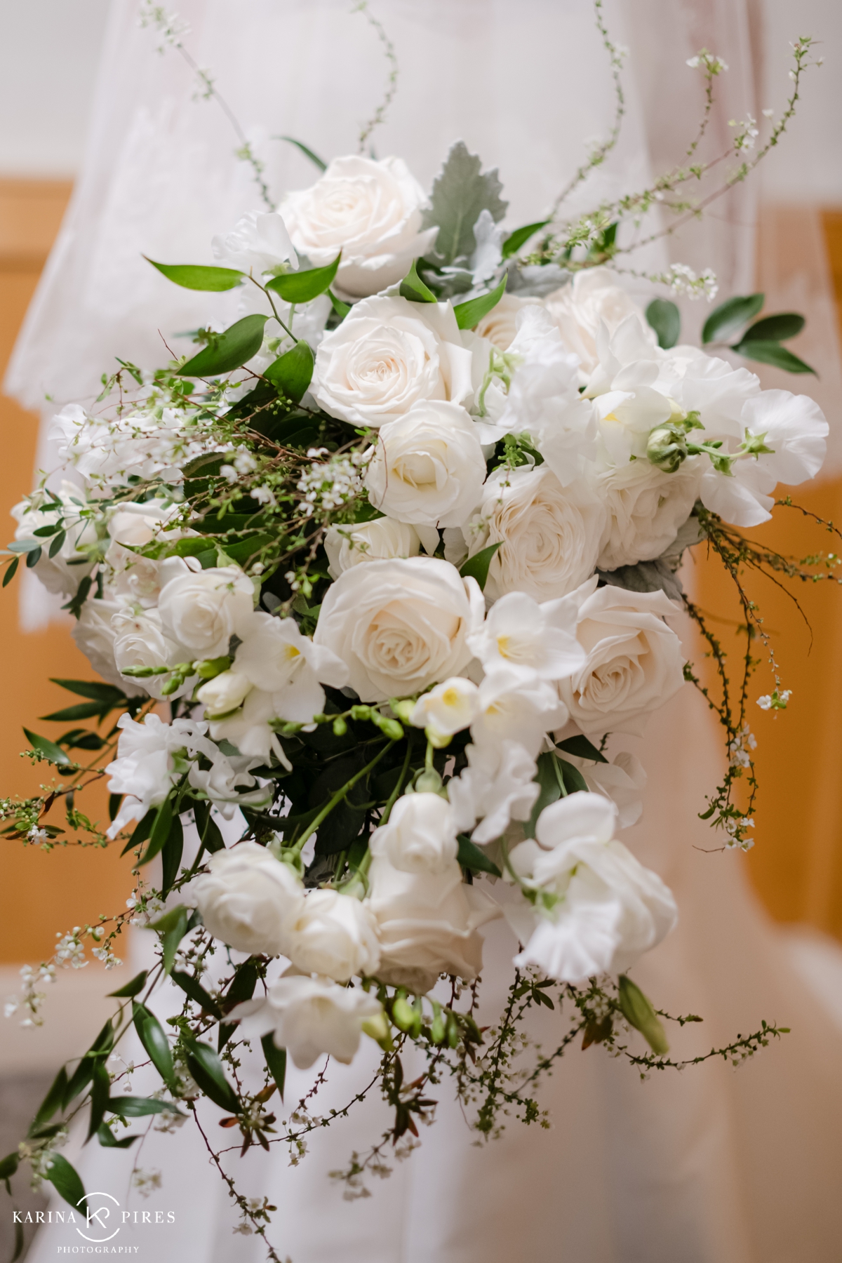 Winter wedding bouquet filled with white flowers and greenery