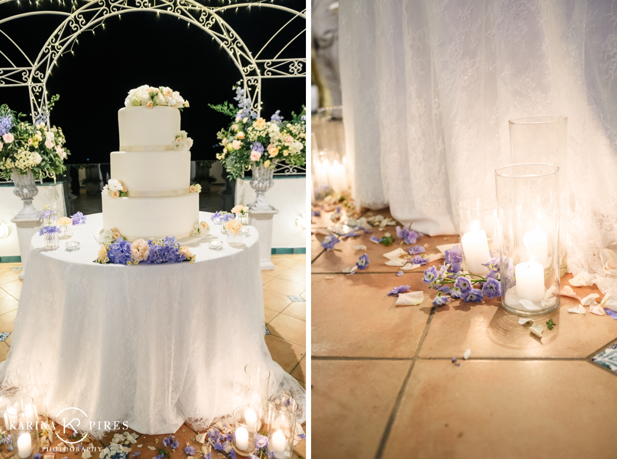 Wedding cake on a round table surrounded by candles and purple flower petals