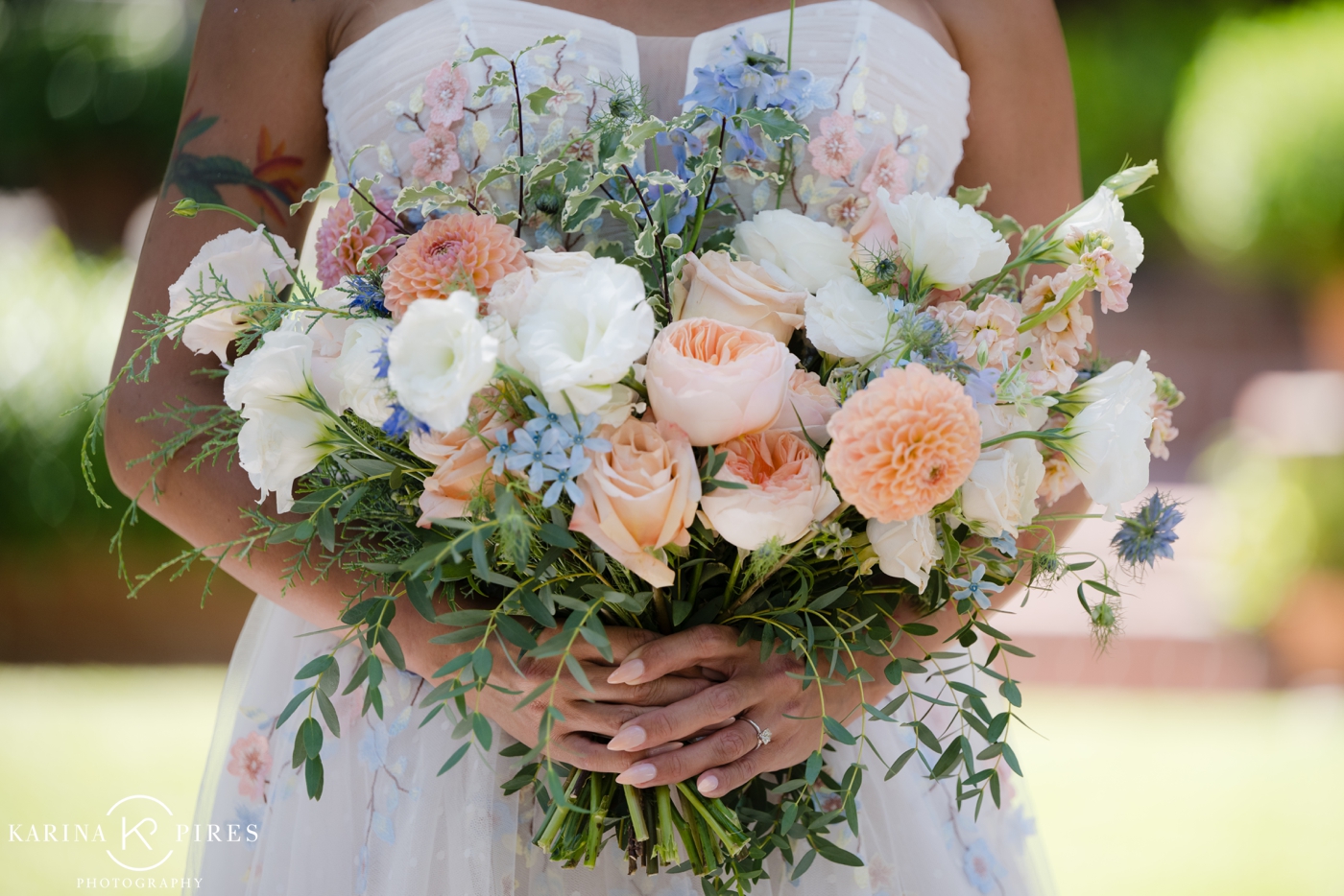 A spring inspired bouquet with peach, cream and blue