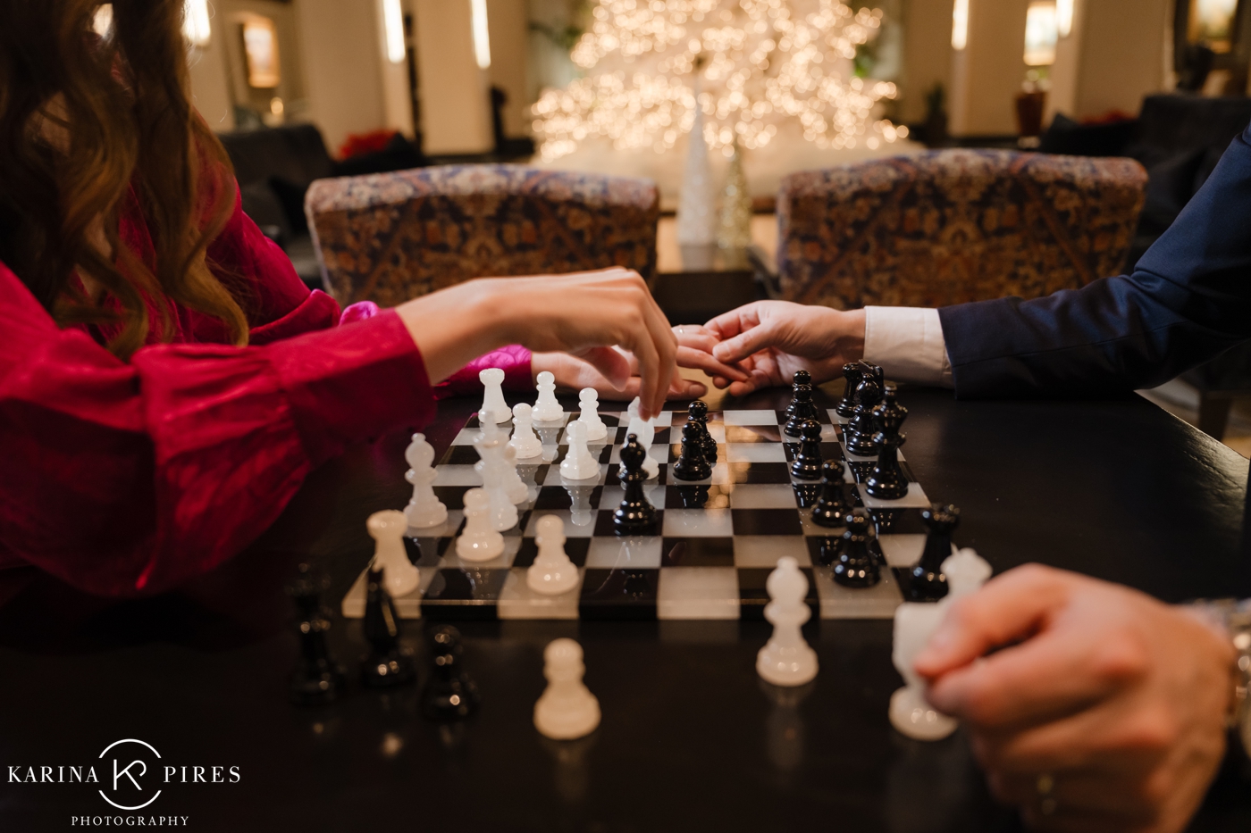 A couple holding hands and playing chess at their downtown LA engagement session at The Jonathan House
