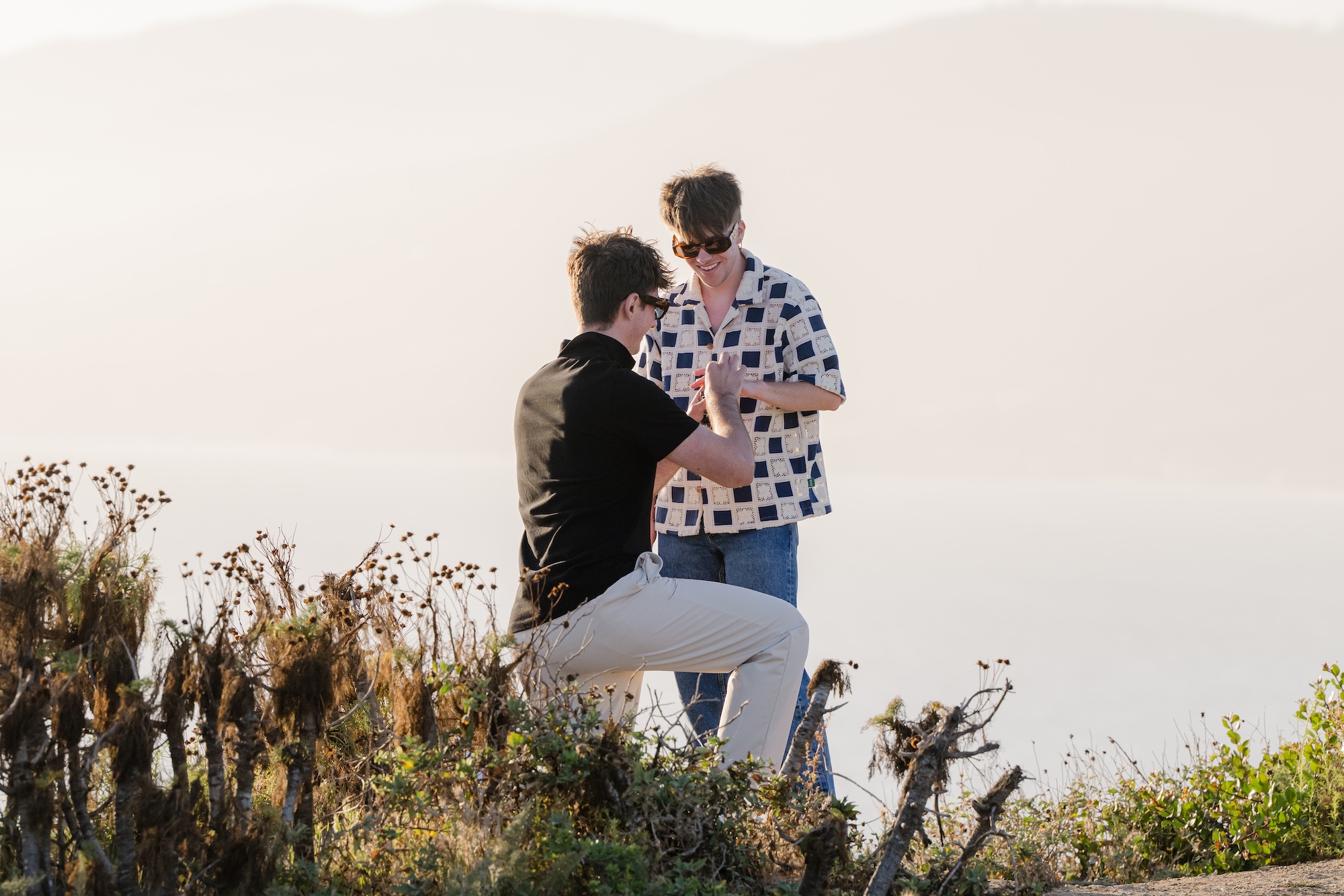 Caleb proposing to Dustin on the bluffs of Point Dume State Beach in Malibu at sunset.