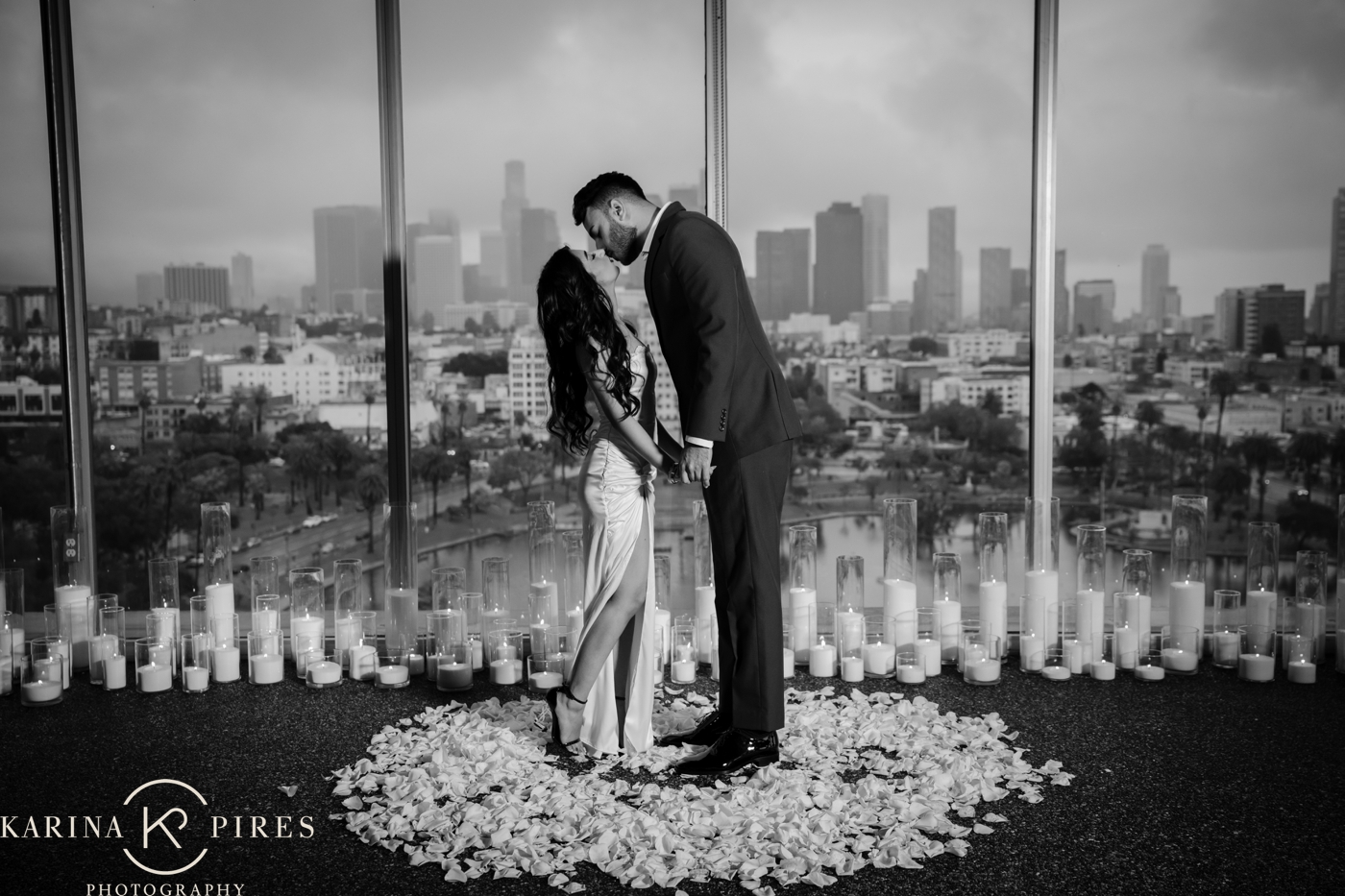 Ritz and Danish kissing during their post-proposal portrait session with the Los Angeles skyline behind them.