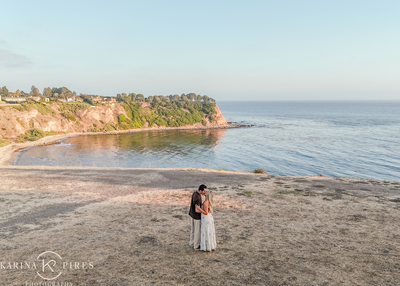 Sunset engagement photos along the coastal bluffs after a Palos Verdes proposal, with the pacific ocean behind them